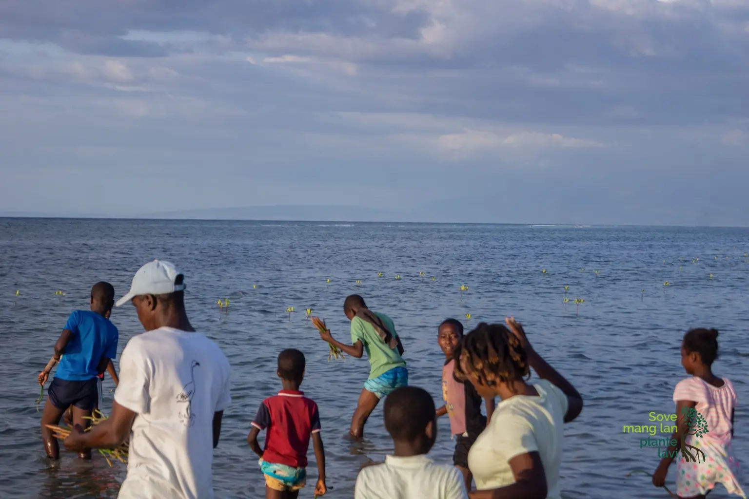 Femmes, jeunes et membres de la communauté participant à une plantation de mangroves