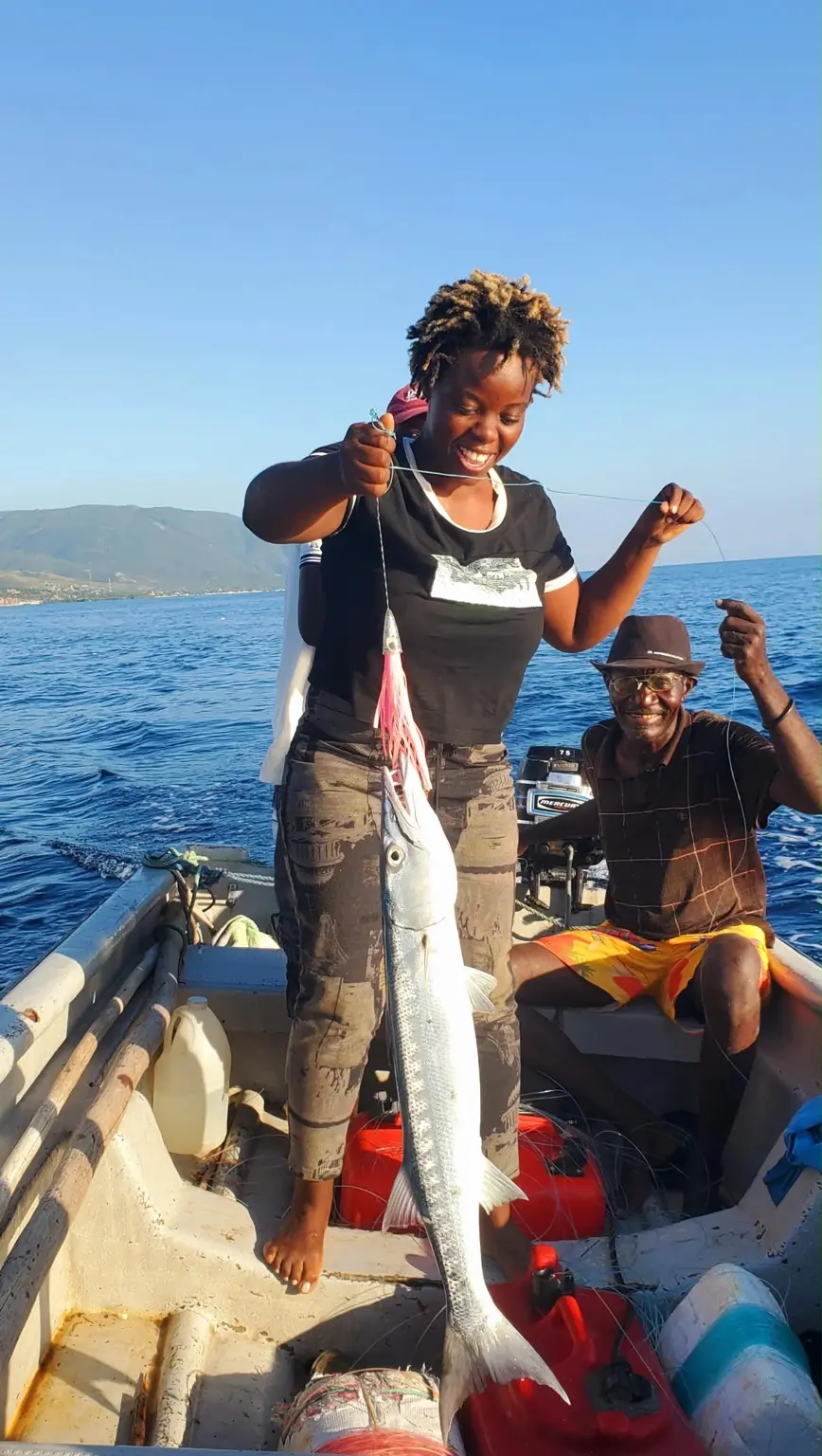 Une pêcheuse de La Gonâve présente sa prise avec un pêcheur expérimenté
