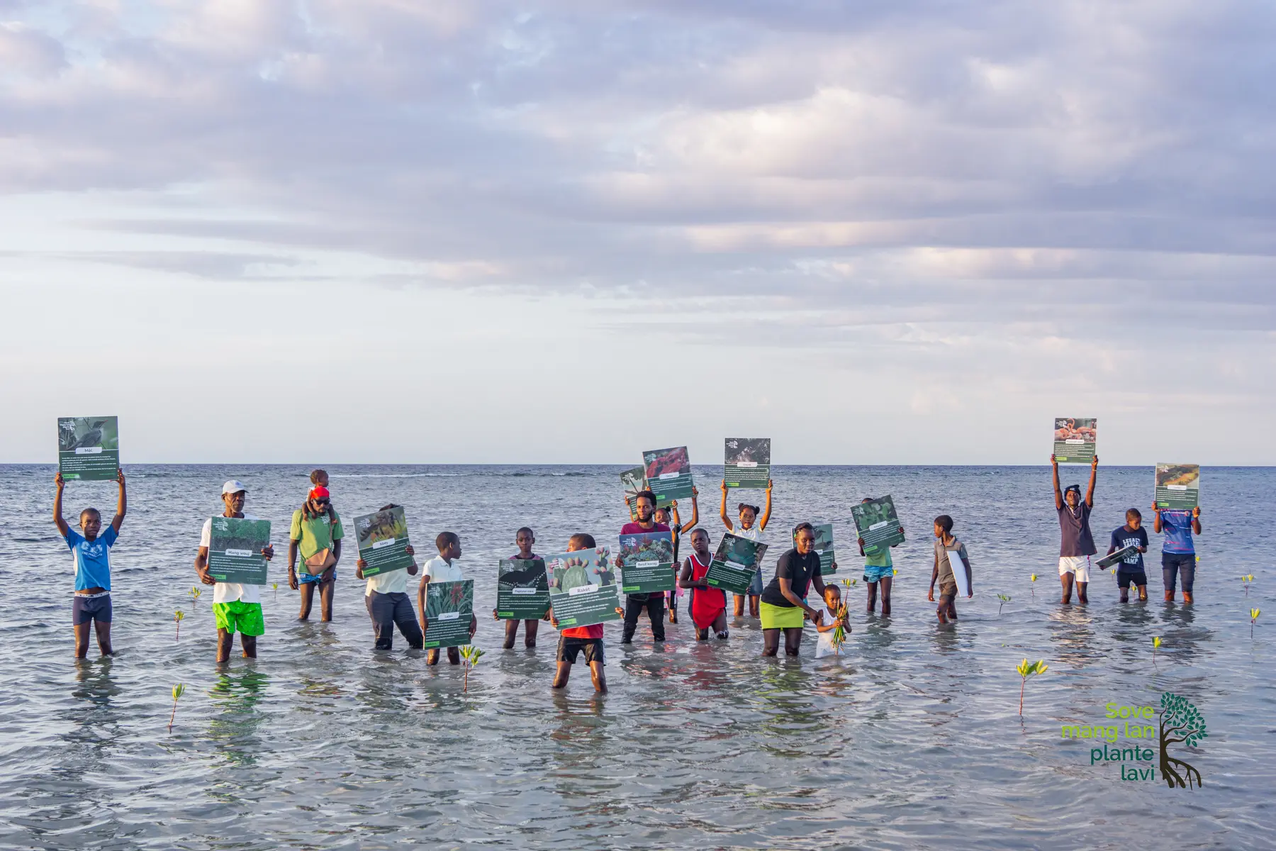 Participants présentant ensemble des messages éducatifs sur le littoral de La Gonâve