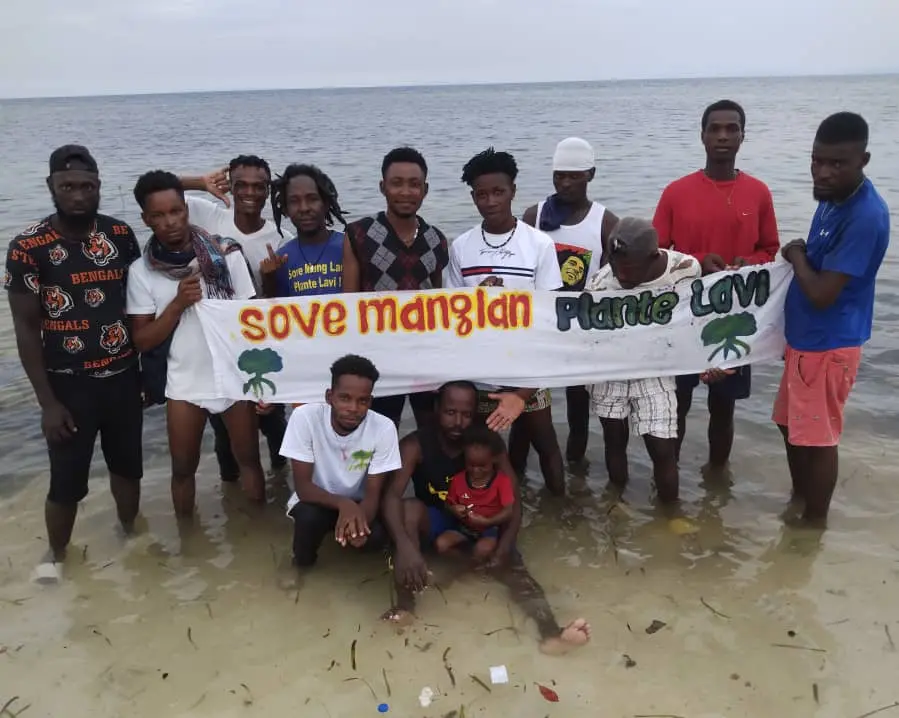 Participants réunis sur le littoral derrière la bannière Sove Mang Lan, Plante Lavi